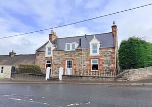 A two-story stone building with a white door and a small window. - Spacious 3BR Cottage in Beautiful Rural Setting - Pass the Keys (Castle Douglas)