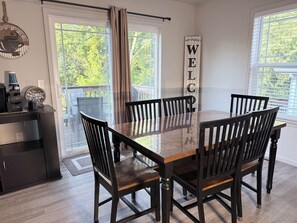 A dining area with a wooden table and chairs, a coffee machine, and a 'WELCOME' sign. - Family Fun: Walk to Landing & Scenic Train (branson)