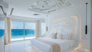 A modern bedroom with a large bed, a view of the sea, and a decorative ceiling. - Meraki Sharm El Sheikh Resort (Sharm El Sheikh)
