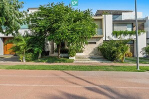 A modern building with a large tree in the front yard, a clear sky, and a BP sign.