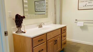 Een bad/douchecombinatie, een haardroger, handdoeken, zeep