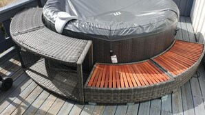 A hot tub with a covered seating area and a small table.