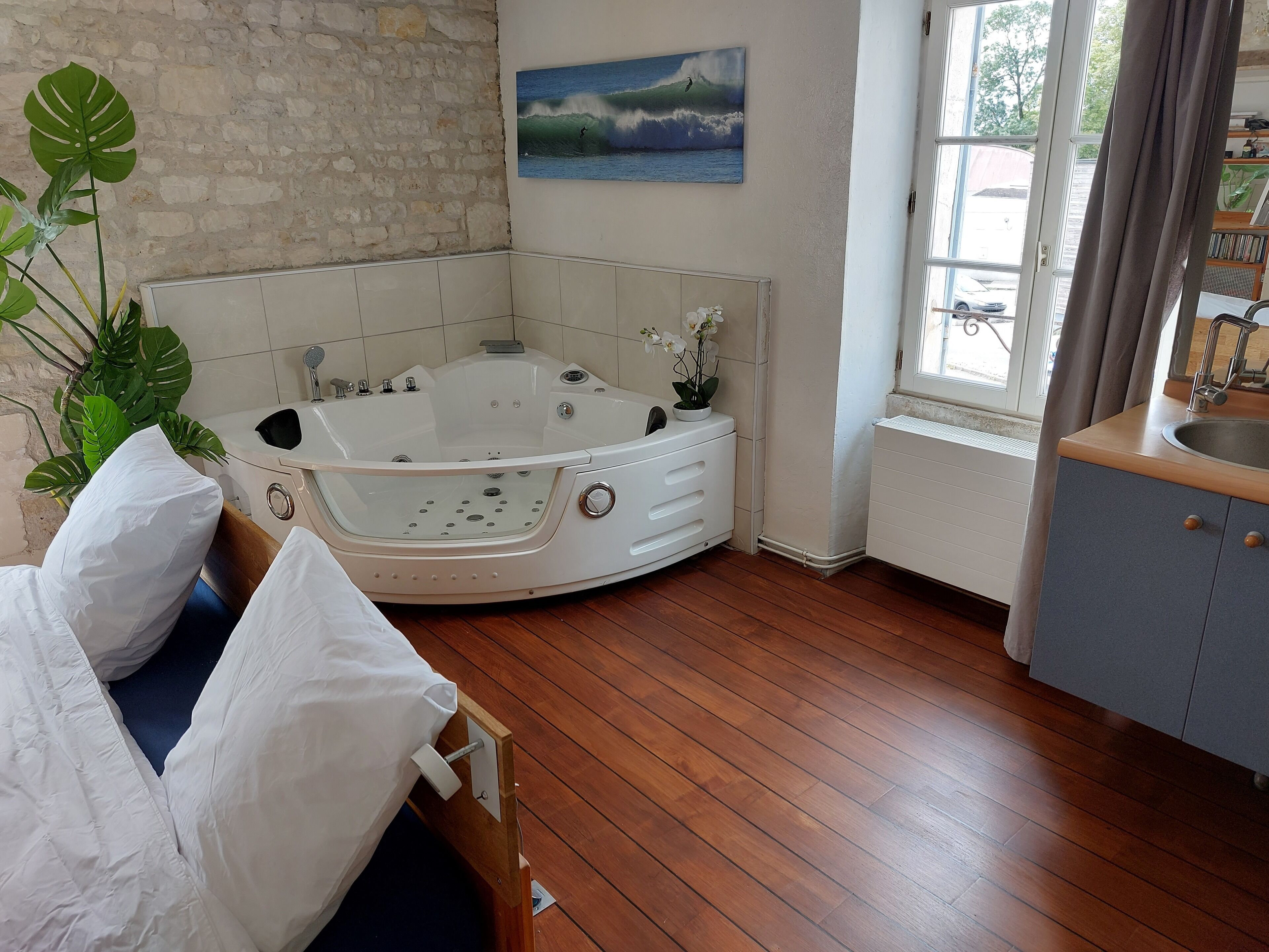 Un baño con bañera, lavamanos y ventana con cortinas.