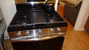 A kitchen with a stove, oven, and kettle. - The College Cottage - Entire Home (Morehead)