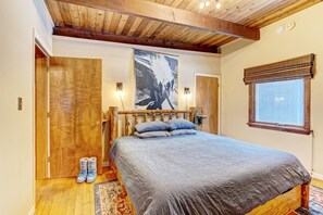 Cozy retreat with a large bed, wooden headboard, and window with a blind.