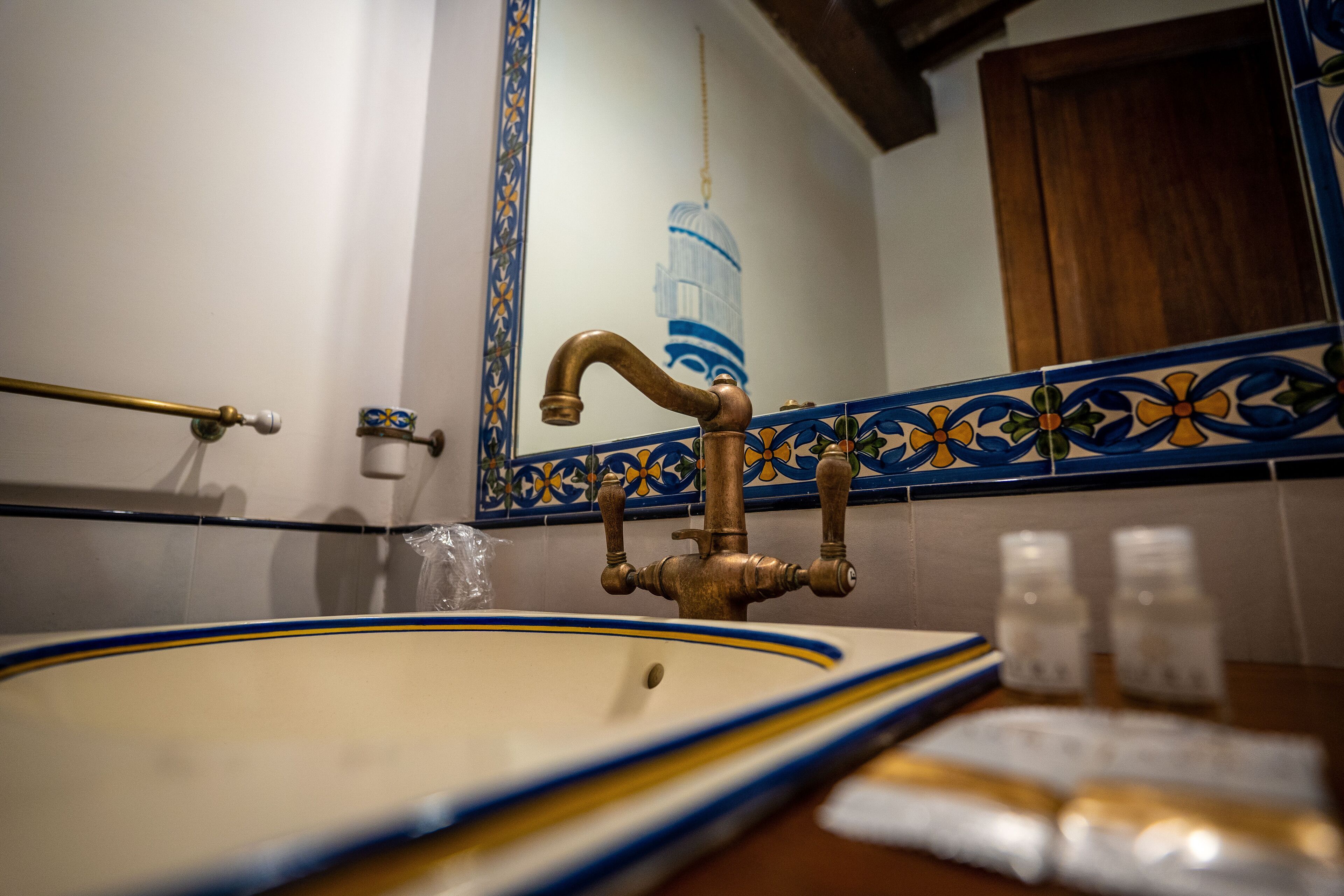 Een badkamer met een wastafel, een kraan en een spiegel.