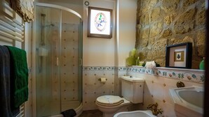 Une salle de bain équipée d’une douche, de toilettes, d’un bidet et d’un lavabo.