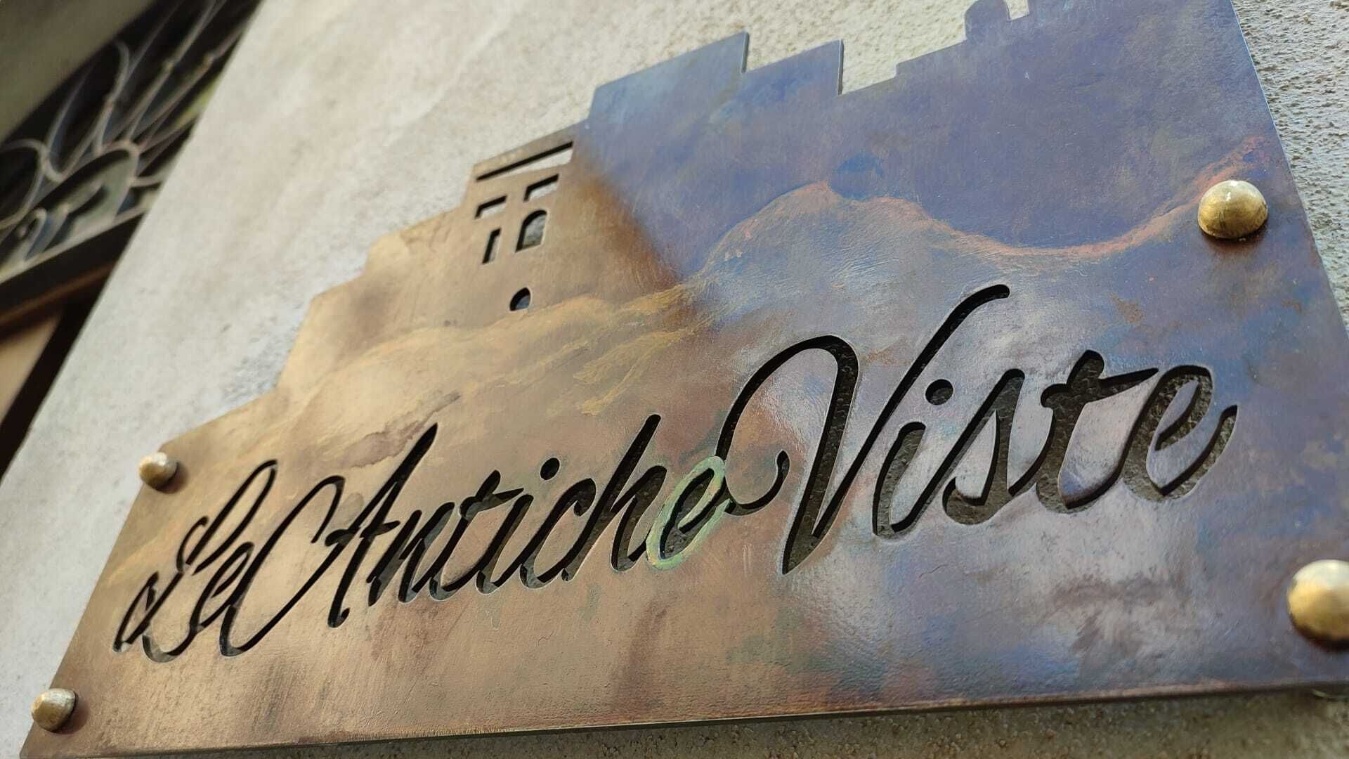 A metal sign with the inscription "El Antiche Viste" mounted on a building.
