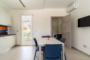 A modern kitchen with white cabinets, a built-in oven, and a large window.