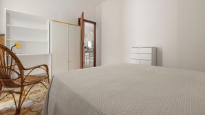 Une chambre à coucher avec un lit, une chaise, une armoire et un miroir.