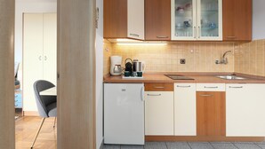A compact kitchen with wooden cabinets, a white refrigerator, and a sink. - FUNTANA Apartments BUDINJAŠ  2, FREE BIKES (FUNTANA)