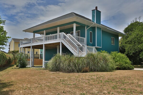 A two-story house with a balcony and a staircase leading to the second floor.