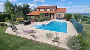 Una casa con piscina, mobiliario exterior y vistas del paisaje circundante.