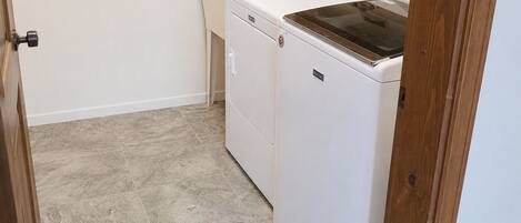 A laundry room with a washing machine, dryer, and sink.