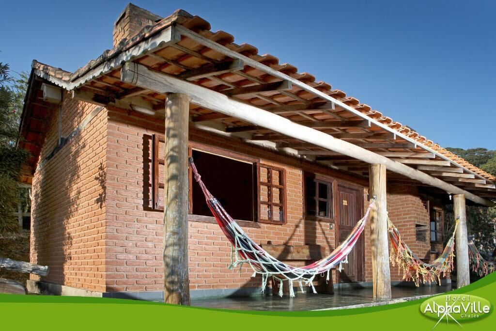 A brick building with a wooden porch and a hammock.