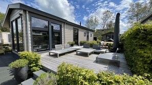 Une maison moderne dotée d’un patio aménagé avec des meubles d’extérieur et des plantes en pot.