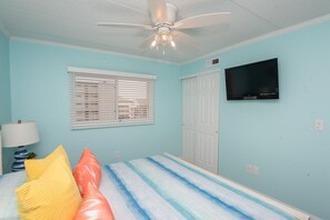 A bedroom with a bed, a ceiling fan, a television, and a window with blinds. - Beautiful Ocean views, Just renovated 2 bedroom 2 bath Condo, 2 parking spots (Ocean City)