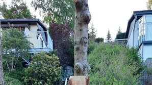 A wooden gate with a tree trunk in the center, surrounded by greenery and a staircase in the background. - Harzglück Albertine 505 (Güntersberge)