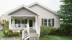 A single-story house with a front porch, a small staircase, and a mailbox.