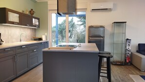 Una cocina moderna con armarios grises, una isla central y una estufa empotrada.