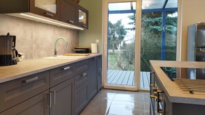 Una cocina moderna con un amplio ventanal, horno empotrado y cafetera.