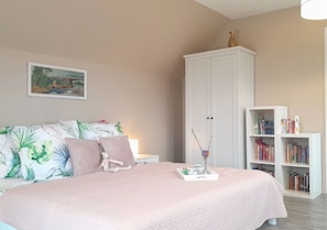 A bedroom with a bed, a nightstand, a bookshelf, and a cabinet. - Villa Aurea a modern house in beautiful surroundings (Nowe Warpno)