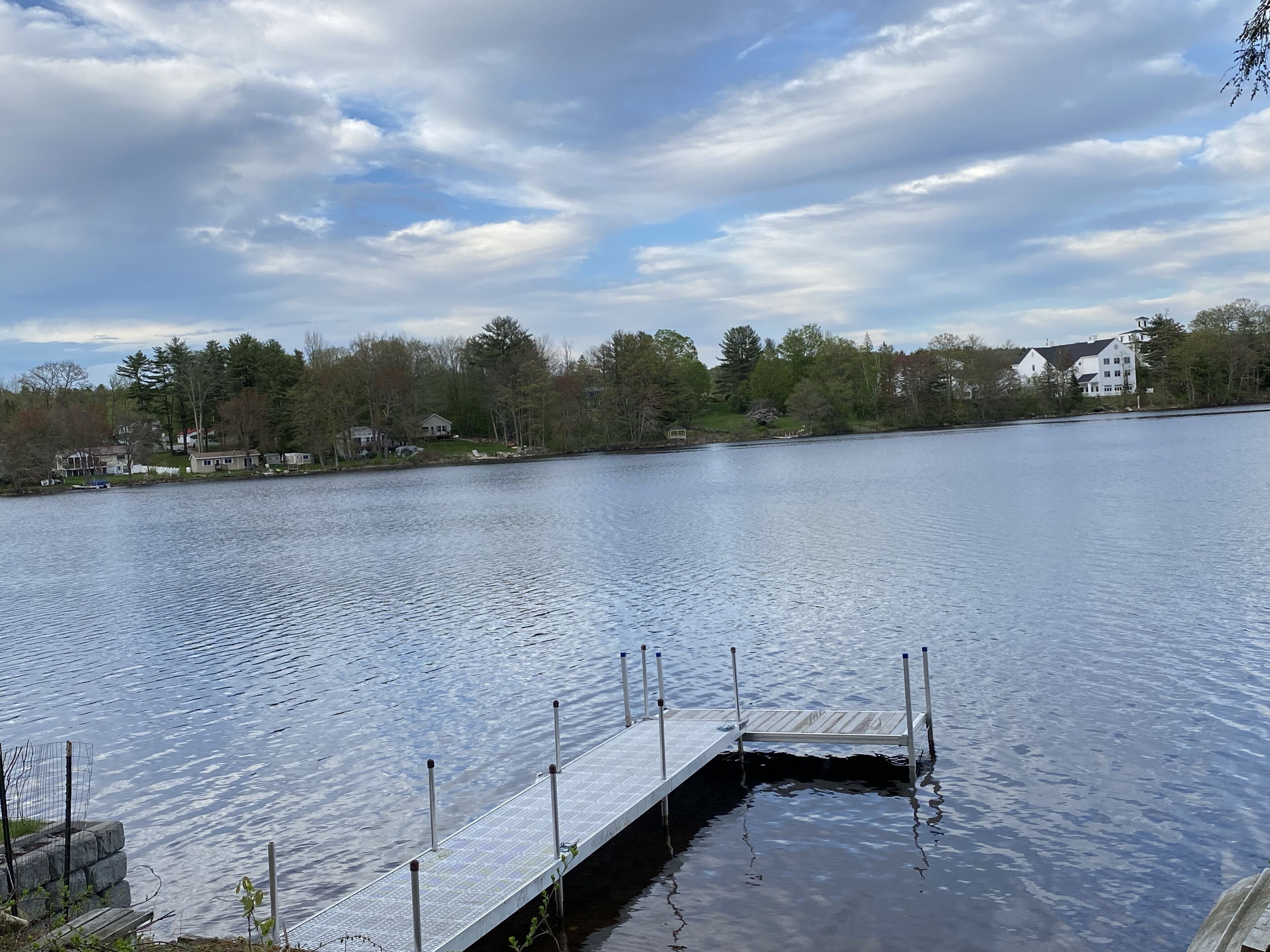 Ein ruhiger See mit einer Holzsteg, der ins Wasser hineinreicht.