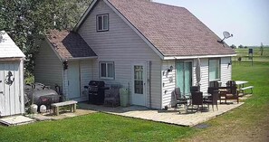Einbungalow mit Veranda, Grill und Gartenmöbeln.