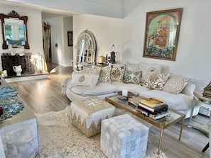 Relax in this stylish living room with a large L-shaped sofa, fireplace, and patterned rug.