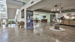 A spacious lobby with a high ceiling, a central seating area, and a reception desk. - On the Brink of the Gulf, 3BR with a 3 Minute Walk to the Beach (Destin)
