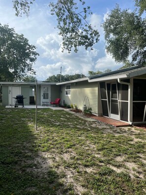 A single-story house with a covered patio, a small outdoor seating area, and a visible garage.