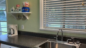 A kitchen with a built-in dishwasher, a stainless steel sink, and a window with blinds. - Cute, clean home on big private lot in Inverness FL. (Inverness)