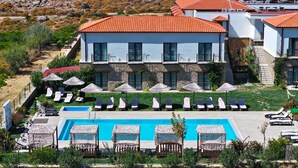 Een hotel met een zwembad, ligbedden en parasols.