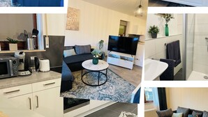 A modern hotel room with a large bed, a dining area, a living room, a kitchen, and a bathroom. - Emma vacation apartment on the Romantic Road (Weikersheim)