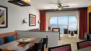 Een moderne hotelkamer met balkon, eethoek en uitzicht op zee.