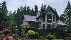 A large, two-story house with a spacious front yard and a covered porch. - Lake front LAWN FLOOR of bi-level home.
 bottom floor only. private entrance. (Dorena)