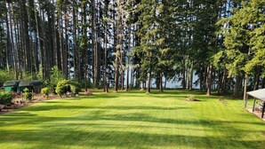 A well-maintained lawn with a gazebo and a covered seating area. - Lake front LAWN FLOOR of bi-level home.
 bottom floor only. private entrance. (Dorena)