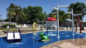 An outdoor playground with slides, climbing structures, and a water feature. - Coastal cottage minutes from the beach.  Large front porch for morning sun!! (Myrtle Beach)