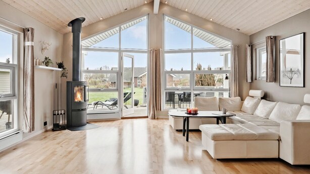 A spacious living room with a large fireplace, a sofa, and a dining area.