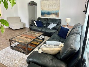 A living room with a sectional sofa, a coffee table, a chair, and a rug.