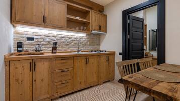A kitchen with wooden cabinets, a stone backsplash, and a dining area with a table and chairs.