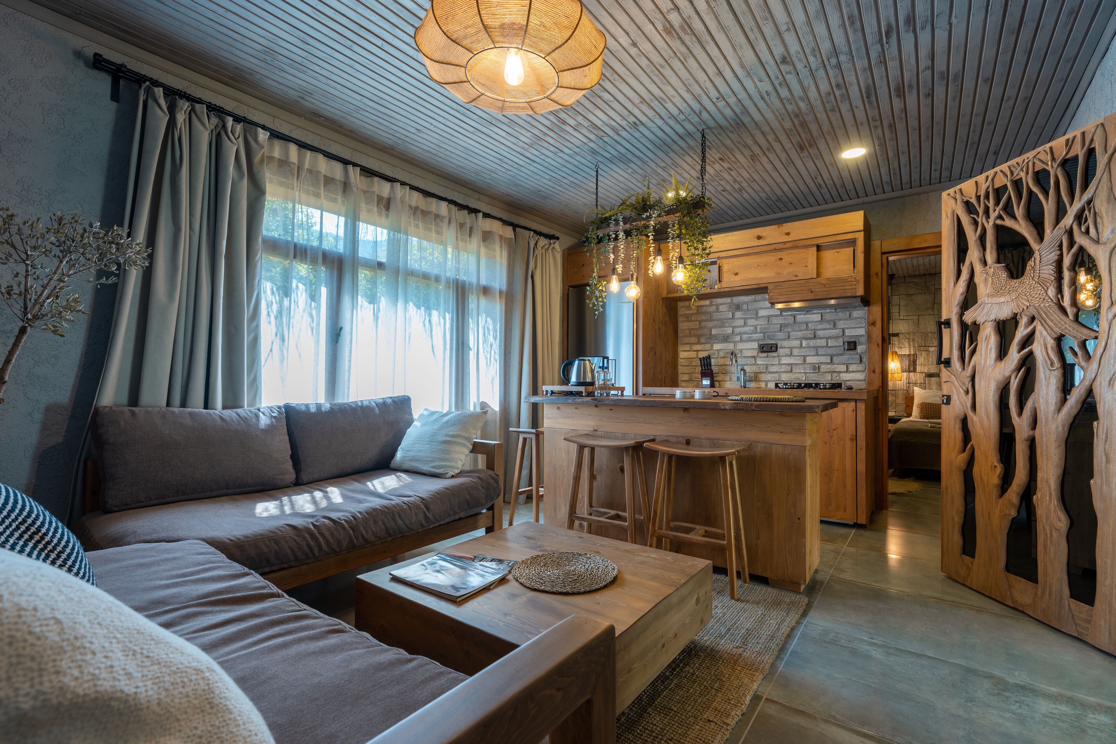 A modern living room with a sofa, coffee table, and a kitchen area with bar stools.
