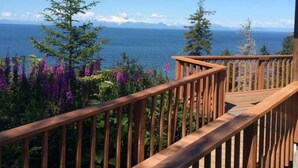 A wooden deck with a view of the ocean and mountains. - Ocean-view Cabins on the Anchor Point Bluff (Anchor Point)