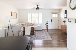Un salon moderne avec un canapé, une table à manger et un ventilateur de plafond.