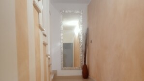 A staircase with a beige carpet leading to a landing with a mirror and a vase. - Business and vacation in an 'oasis of peace!!! (Valdarenne)