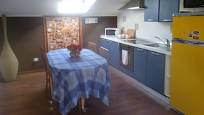 A compact kitchen with a blue table, a yellow refrigerator, and a microwave. - Business and vacation in an 'oasis of peace!!! (Valdarenne)