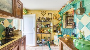 A kitchen with wooden cabinets, a white door, and various kitchen utensils and appliances. - 2 bedroom nice home in Saint Laurent d'Olt (Saint Laurent d'Olt)