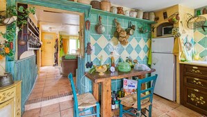 A kitchen with a wooden table, chairs, and various kitchen items. - 2 bedroom nice home in Saint Laurent d'Olt (Saint Laurent d'Olt)