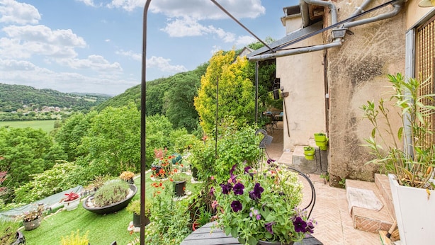 A garden with various plants and flowers, a wooden table, and a view of the countryside. - 2 bedroom nice home in Saint Laurent d'Olt (Saint Laurent d'Olt)