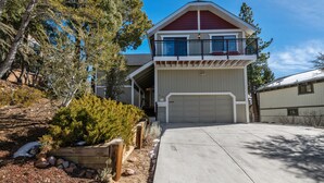 A two-story house with a garage, a balcony, and a well-maintained garden. - Game Cabin with 5 PM Late Checkout (Big Bear)